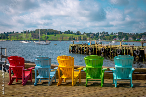 Multicolour Adirondack chairs facing bay, Lunenburg harbour, Nova Scotia, Canada. Photo taken in September 2023. photo