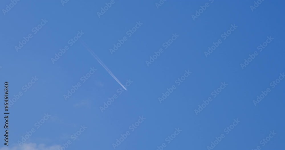 Airplane flying on deep blue sky with chemical direction trails Airplane flying on deep blue sky with chemical direction trails