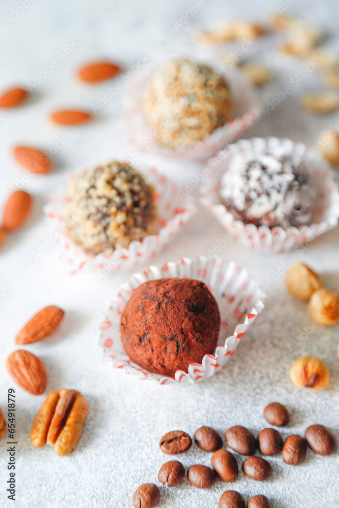 Superfood, raw healthy vegetarian snack, Medjool dates covered by chocolate, and various energy balls with nuts.