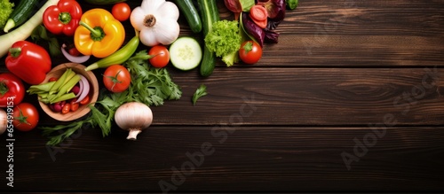Top view of fresh vegetable and salad bowls on kitchen wooden worktop promoting healthy eating with empty space at center with copyspace for text