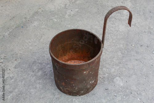 Liquid measurement cup with handle. Old metal container used to measure kerosene. photo