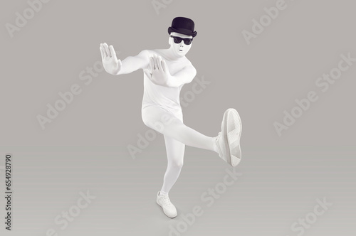 Full length portrait of faceless unrecognizable person wearing white skinny bodysuit costume with black glasses and hat. Incognito funny man walking isolated on studio grey background with copy space