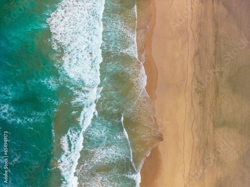 Epische Luftaufnahme zeigt raue Küste, türkisblaues Wasser und hellen Strand von oben - Naturschönheit und wilde Brandung vereint photo