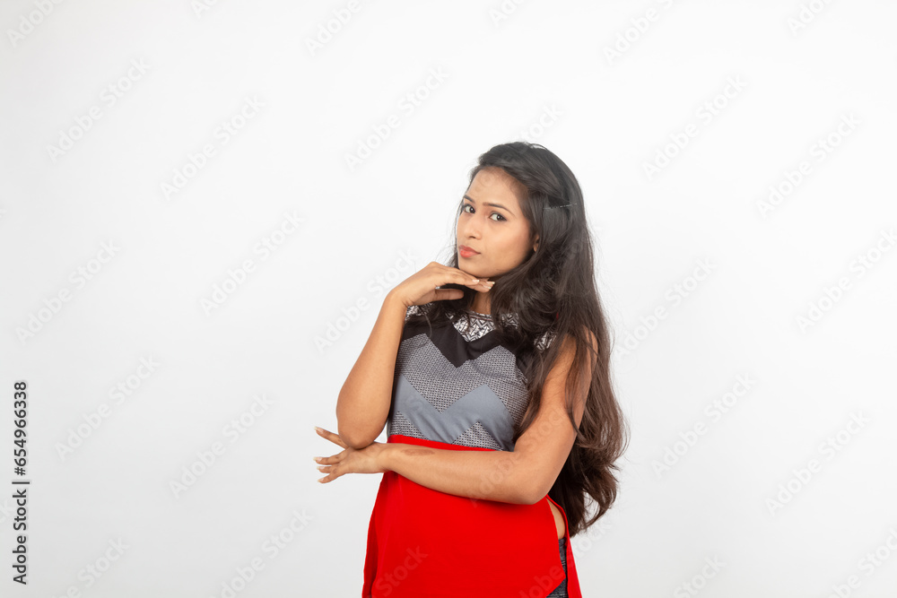 Studio shot of a young, beautiful Indian female model in casual wear wearing red and grey designer top and black jeans against white background. Female model. Fashion Portrait. Studio shot of a young, beautiful Indian female model in casual wear wearing red and grey designer top and black jeans against white background. Female model. Fashion Portrait.