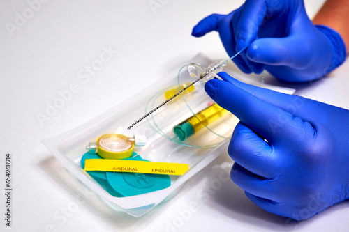 Needle for epidural anesthesia. Epidural anesthesia in medicine. Epidural anesthesia kit and doctor's hands in protective gloves close-up