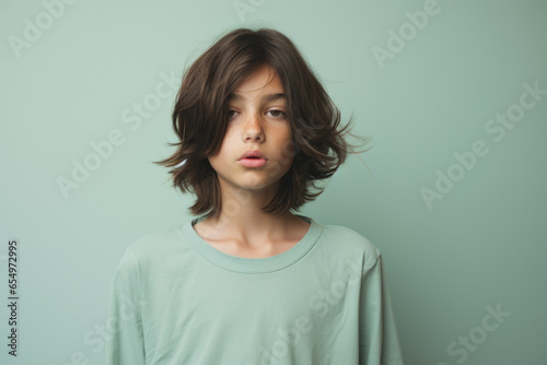 A young boy wearing a green shirt poses for a picture. This versatile image can be used in various contexts.