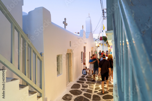 Unknown people coming and going on a narrow street in Mykonos photo