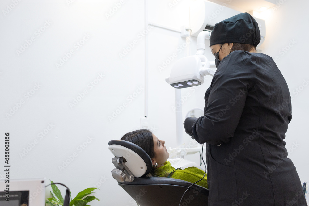 Dental scene. Dentist attending to patient. Views from behind. Copyspace