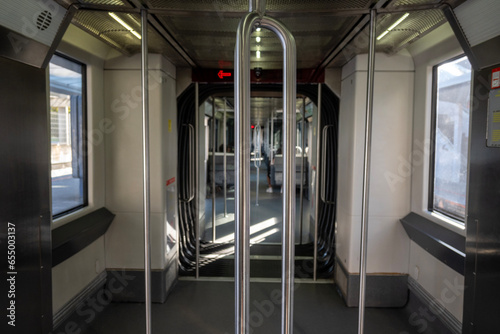 Interior del vagón del metro, donde los pasajeros ocupan los asientos dispuestos a lo largo del compartimento. algunos pasajeros están absortos en la lectura de libros o en sus dispositivos móviles. photo