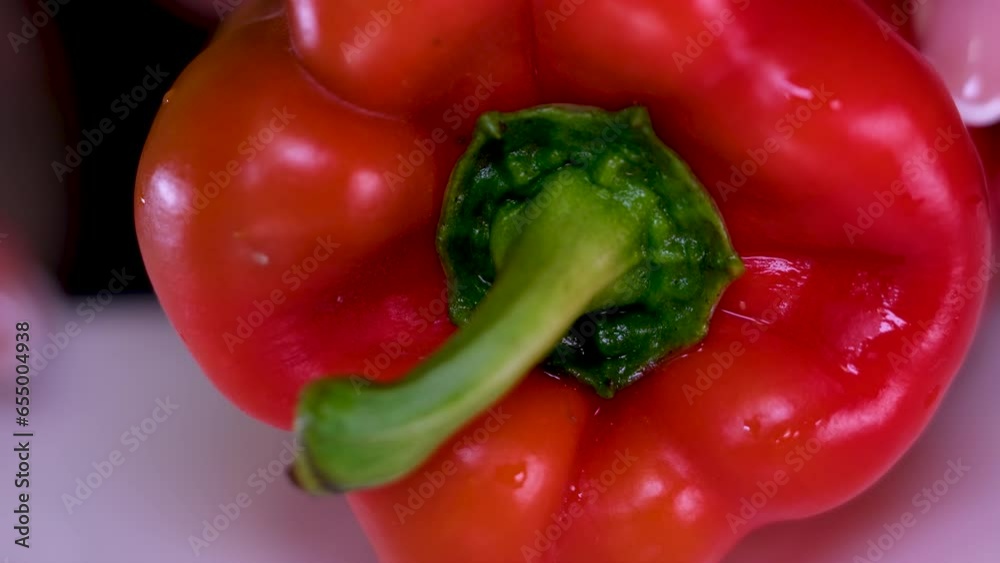 Professional cook in gloves cuts ripe red bell pepper with water drops on brown wooden board in restaurant extreme closeup. High quality 4k footage Professional cook in gloves cuts ripe red bell pepper with water drops on brown wooden board in restaurant extreme closeup. High quality 4k footage