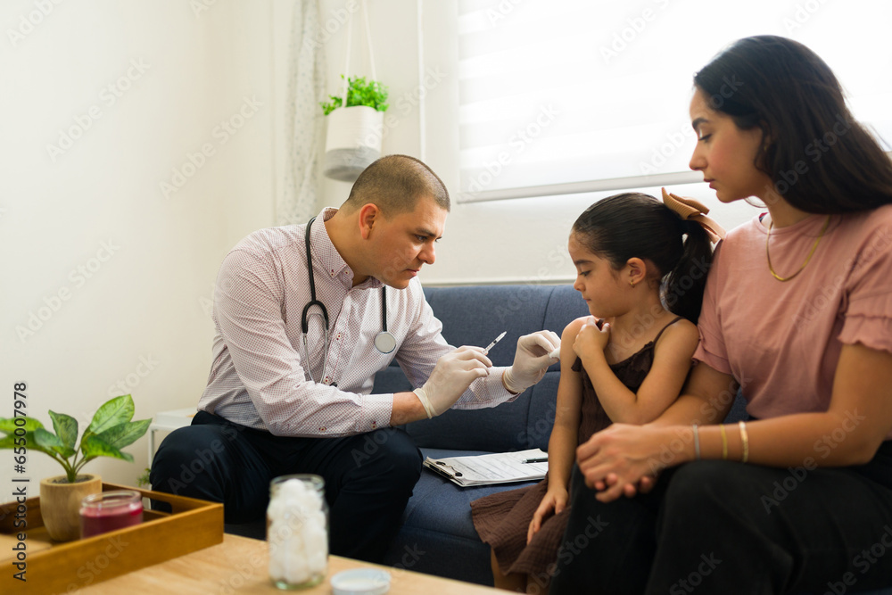 Hispanic child getting a vaccine during a doctor's visit Hispanic child getting a vaccine during a doctor's visit