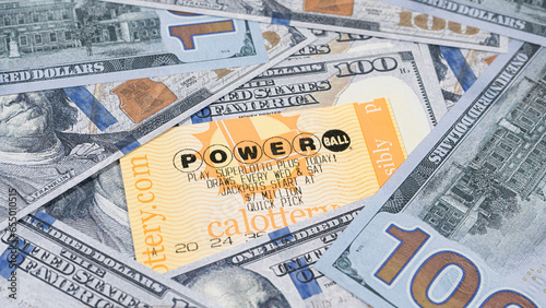 Lake Elsinore, CA, USA - September 30, 2023: Focus on Powerball lottery tickets surrounded by US currency. photo