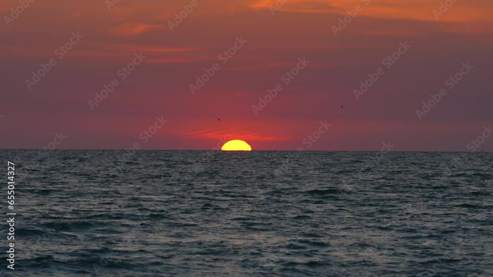 Big yellow sun on dramatic bright sky. Ocean sunset. Soft evening horizont over sea dark water Big yellow sun on dramatic bright sky. Ocean sunset. Soft evening horizont over sea dark water