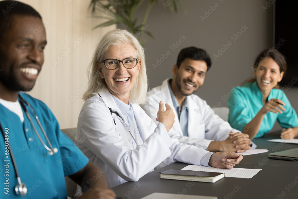 © fizkes - Diverse team of positive different aged doctors meeting at table, talking, laughing, having fun. Medical professional colleagues discussing job, occupation, collaboration in hospital © fizkes - Diverse team of positive different aged doctors meeting at table, talking, laughing, having fun. Medical professional colleagues discussing job, occupation, collaboration in hospital