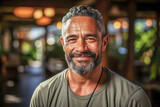 Handsome middle-aged Pacific Islander man in his fifties, smiling, radiating warmth and positivity, expressing confidence and joy.