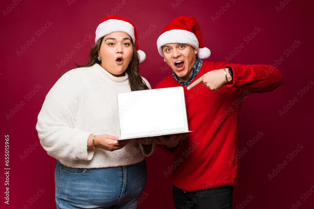 Excited couple doing online shopping on christmas Excited couple doing online shopping on christmas
