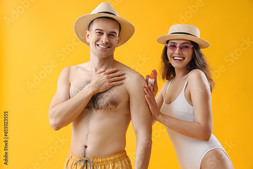 Young couple applying sunsc...