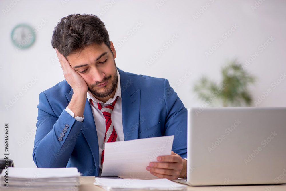 Young male employee working in the office Young male employee working in the office