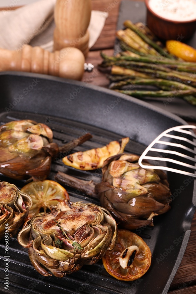 Tasty grilled artichokes on table, closeup view