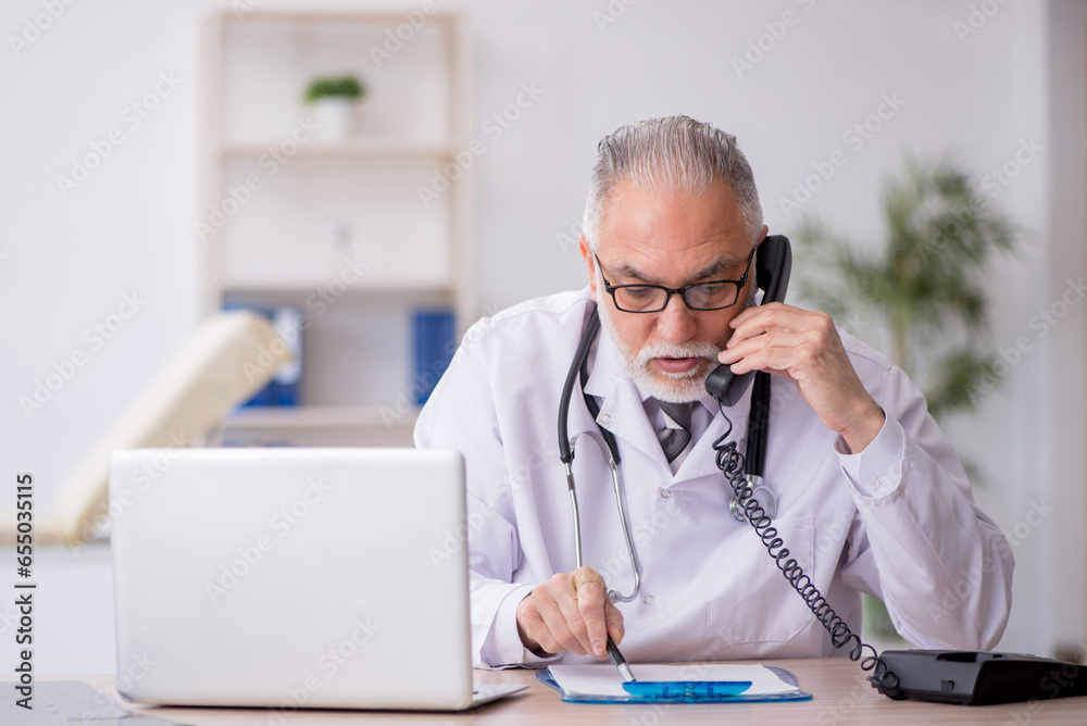 Old male doctor in telemedicine concept Old male doctor in telemedicine concept