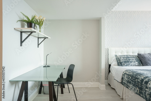 Stock photo of a bedroom with modern glass word desk for those who telecommute and work from home