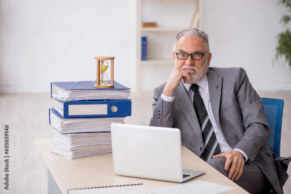 Old male employee in time management concept