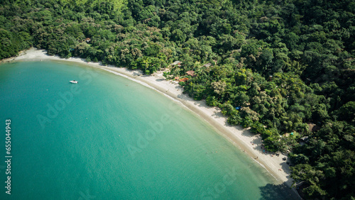 Beach landscape on a sunny day, seen from above, drone photography, calm turquoise waters, with a small island in the foreground, mountains with forest, Praia da Justa, Ubatuba - Sao Paulo - Brasil photo