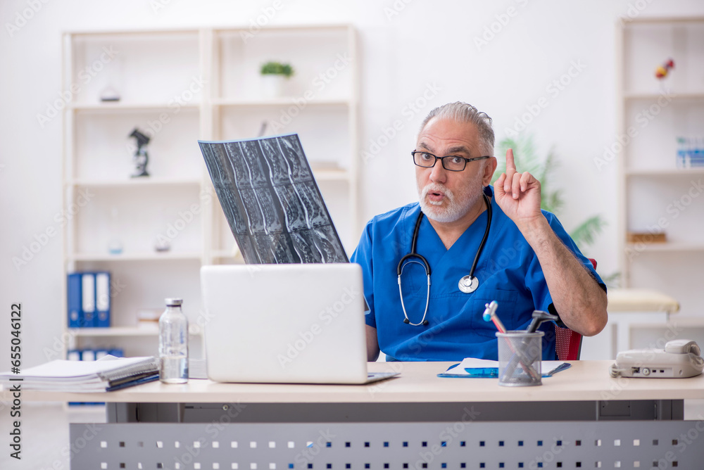 Old male doctor radiologist working in the clinic