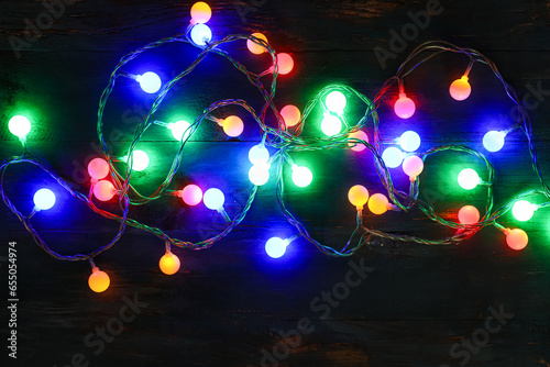 Beautiful Christmas lights on wooden background
