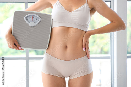 Young woman holding weight ...