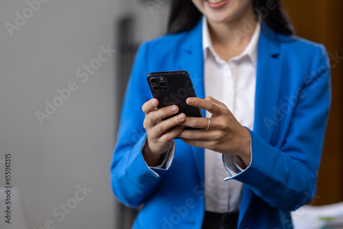 Portrait of positive asian woman entrepreneur busy with her work in the office. Young Asian female accountant relaxing on her mobile application.