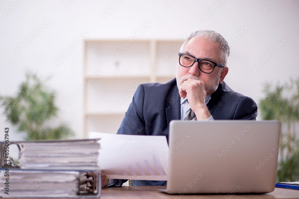 Old male employee and too much work at workplace Old male employee and too much work at workplace