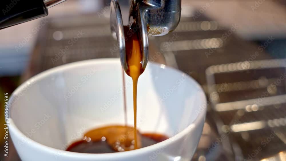 coffee pouring from dual pipe coffee machine into a white glass