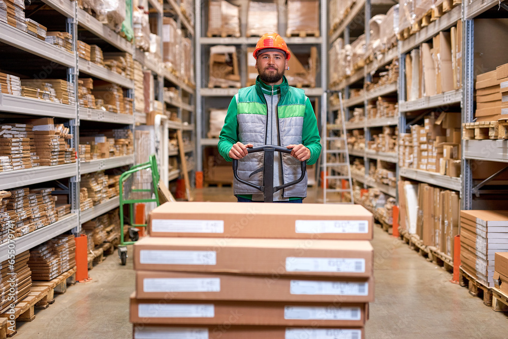 Skilled warehouse employee pushing manual pallet jack and working in factory storage room, warehouse worker transporting cardboard goods delivery. logistics and distribution concept Skilled warehouse employee pushing manual pallet jack and working in factory storage room, warehouse worker transporting cardboard goods delivery. logistics and distribution concept