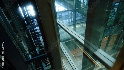 Modern transparent glass elevator moving up in skyscrapers or shopping center. The elevator going up. photo