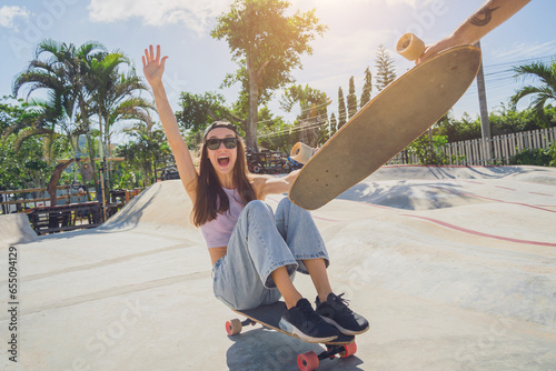 Young happy couple with skateboards enjoy longboarding at the skatepark photo