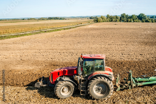 Tractor in the field. Agricultural machinery. Agricultural farm tractor during tillage of soil and field after harvest.