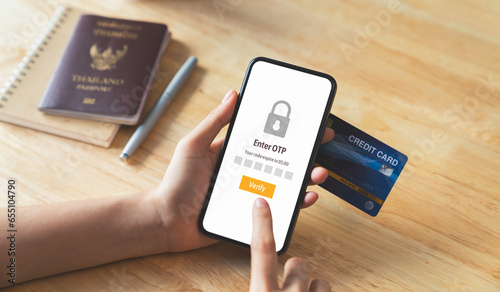 Woman hand using smartphone and mobile OTP secure verification screen with enter password for login banking account on on desk.