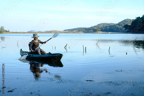 Asia women on kayak rows in the reservoir during the sunrise, Harirak forest park Huai Nam Man reservoir Loei Thailand 21 Jan 2023