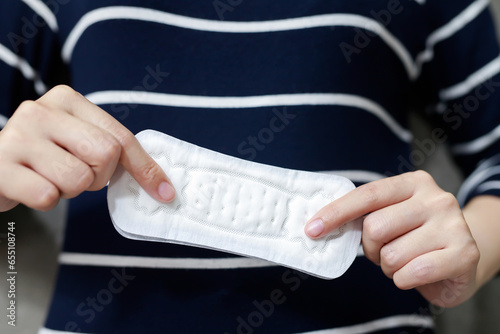 Female Hygiene. Close Up Young woman holding a Clean Period slim sanitary napkin pad. Reports daily menstrual period day use on every month. Feminine Intimate Product. health care concept.