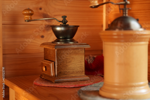 木製の壁の前の棚に置かれたコーヒーミル