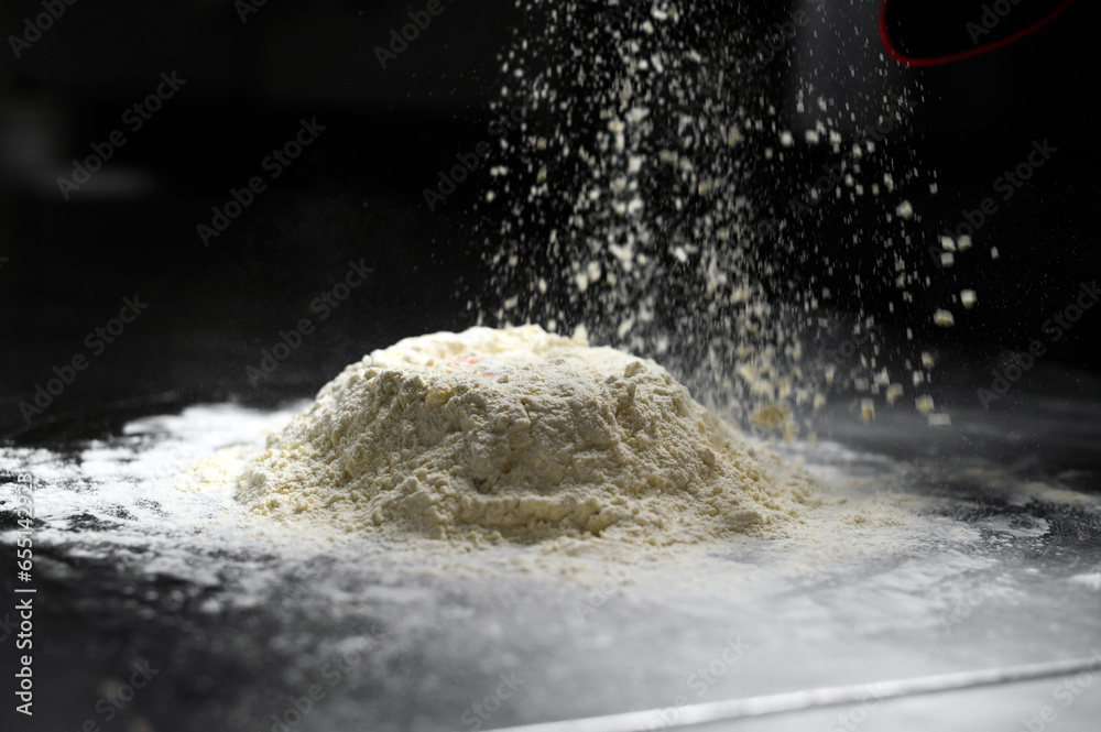 Flour pours on fresh homemade dough Flour pours on fresh homemade dough