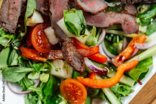 food, cooking and eating concept - close up of duck meat with vegetable salad on plate