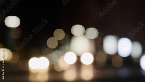 Bokeh background of night city with car light passing by