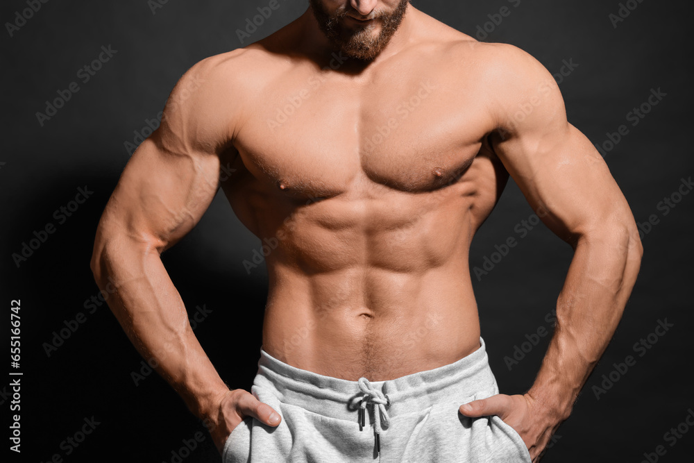 Muscular man showing abs on black background, closeup. Sexy body Muscular man showing abs on black background, closeup. Sexy body