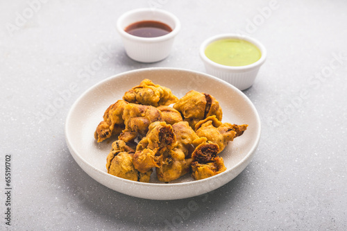 cauliflower fritters with sweet and sour chutney, served hot on a white plate