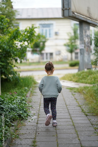 little child walking on the street © Marius