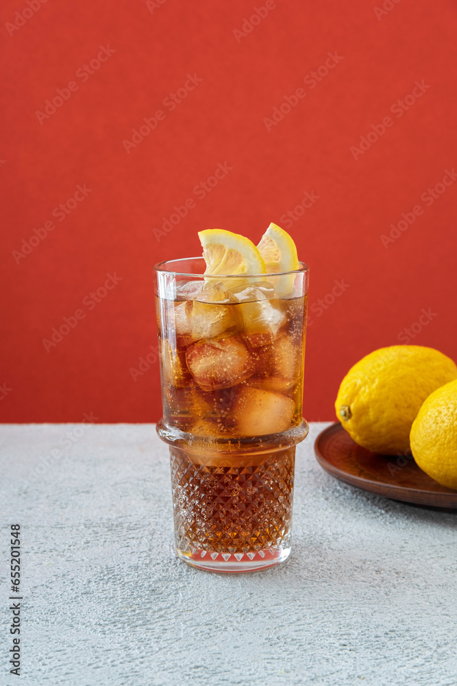 Long Island iced tea cocktail garnished with lemon slice in highball