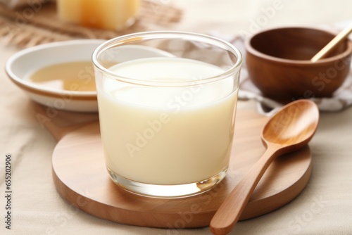 warm milk and honey in a clear cup with a spoon