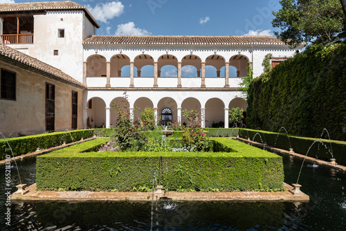 Patio de la Sultana in the Almunia Palace of the Generalife with views of the garden, dry cypress and arches of the palace facade